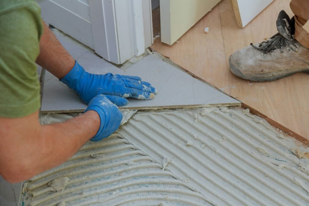 Plaster repair work laying tile, trowel in a man hand