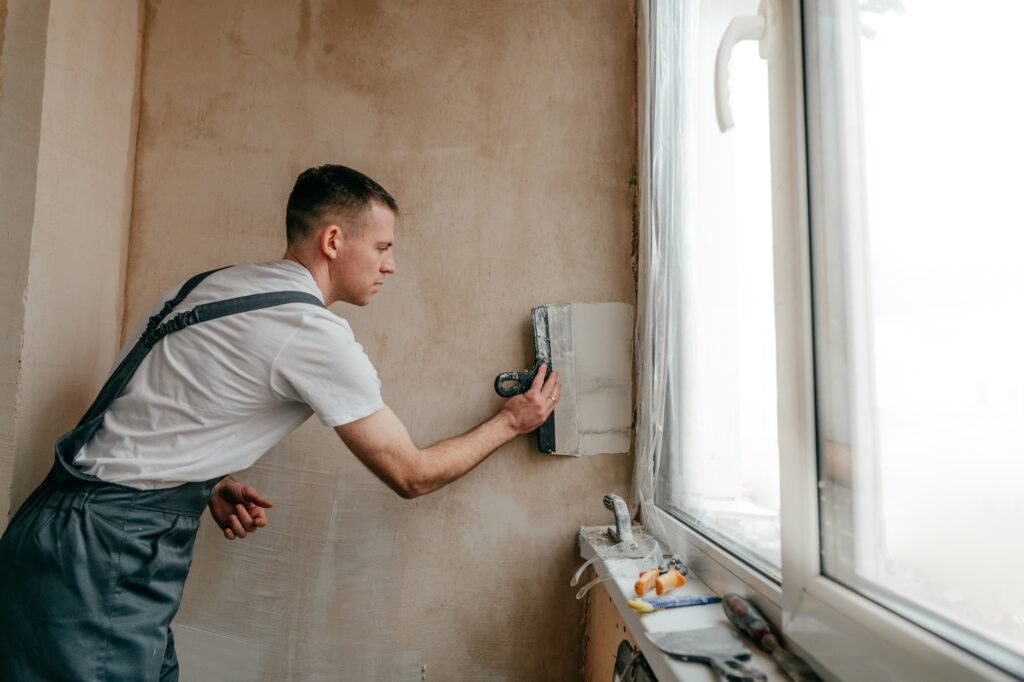 Worker applying putty mortar on the balcony wall